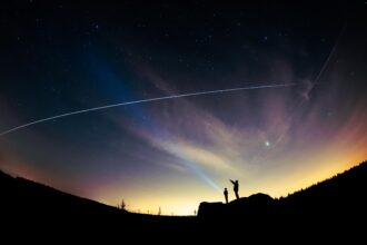 Enquanto um pai e seu filho observam, a Estação Espacial Internacional passa por cima deles. A imagem foi capturada em Little Almscliffe Crag, Beckwithshaw, Harrogate, North Yorkshire.