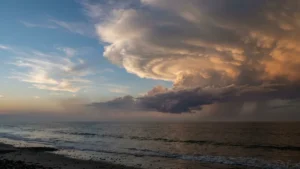 Foto de céu dramático ao entardecer com nuvens de tempestade em espiral sobre o oceano e céu claro ao lado